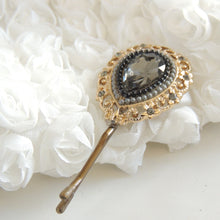 Decorative hairpin with gemstone on a white floral background

