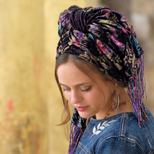 Woman wearing a colorful headscarf with a blurred background

