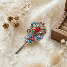 Decorative brooch with colorful gemstones on a lace background

