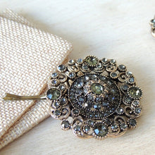 Decorative hair pin with gemstones on a textured surface

